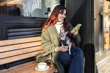 Woman Relaxing with Smartphone and Cute chihuahua at Coffee Shop