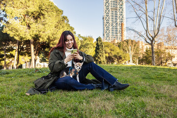 Young woman with chihuahua enjoying a sunny day in the park