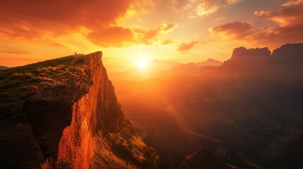 Naklejka premium Majestic Sunset over Mountain Clifftop, Solitary Figure Witnessing Nature's Spectacle