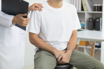 Obraz premium A young man suffering from erectile dysfunction seeks consultation with a specialist to identify the cause of his erectile dysfunction and seek treatment or cure for the erectile dysfunction.