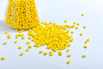 Yellow masterbatch granules in Erlenmeyer flask isolated on white background, color pigment carrier...