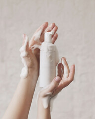 Woman washing hands with soap on white stone background. Aesthetic clinic concept. 