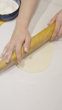 Persona amasando y expandiendo una masa con un palo de amasar y las manos. Footage de cocina, gastronom&iacute;a, lifestyle.