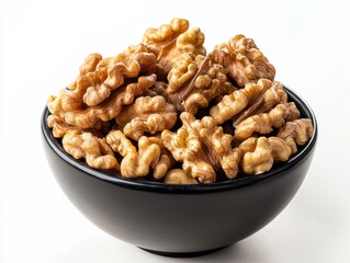 Fototapeta premium Fresh walnut halves in a black ceramic bowl with clean presentation
