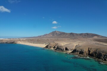 Obraz premium Aerial panorama of LANZAROTE coastline with beaches and volcanic mountains near National Park area of Canary Islands near Playa Blanca