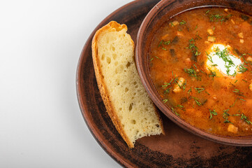 Traditional Ukrainian borscht in a rustic clay bowl, served with sour cream and fresh dill, accompanied by a slice of homemade bread. Classic Slavic cuisine and comfort food