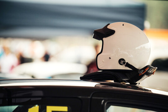 Racing helmet on car roof emphasizing motorsports safety