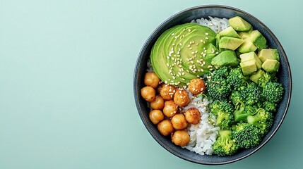   A dish featuring a bowl of rice, broccoli, chickpeas, and avocado set against a blue backdrop