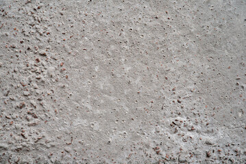 Gray concrete surface with small holes and irregularities