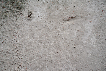 Porous gray concrete surface with small holes and irregularities