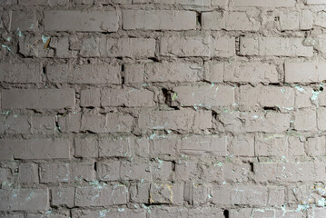 Old brick wall painted pink with cracks and peeling paint