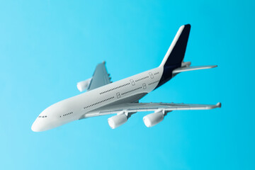Plane model in air on light blue background, closeup