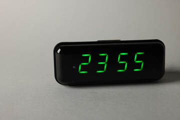 Digital alarm clock showing 23:55 o'clock on grey background, space for text