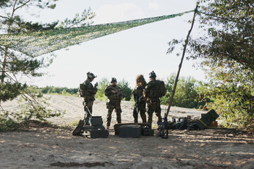 A military unit dressed in uniforms departs the base, leaving equipment crates behind, advancing...