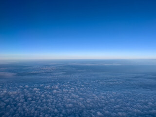Fototapeta premium Airplane view of white cumulus clouds on turquoise horizon