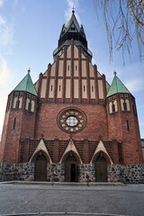 facade historic, neo-gothic catholic church with bell tower in the city of Poznan