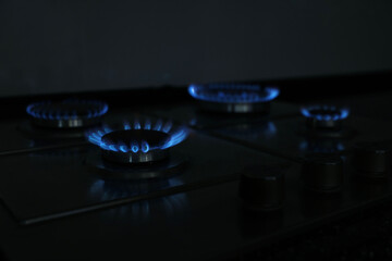 Gas burners with blue flame on stove, closeup