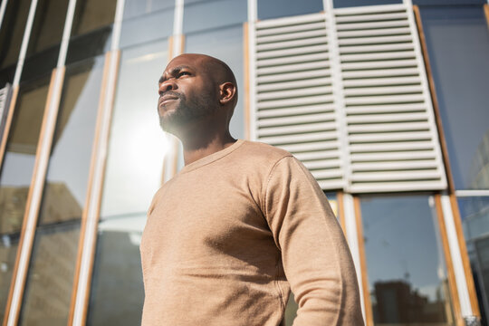 Confident Cuban Man Standing in Front of Modern Building