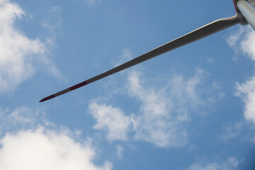 A wind turbine with a blue sky and clouds.  Concept of clean energy.