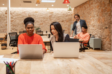 Collaborative workspace with diverse professionals at laptops