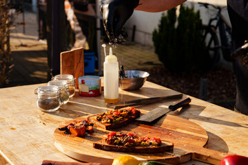 Grill master preparing bread with grilled vegetables and meat at a grill party