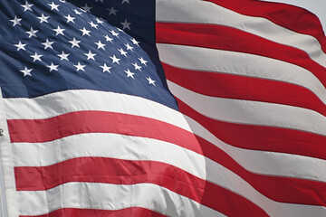 Obraz premium Close up full frame of United States of America flag flying in the wind with blue sky background