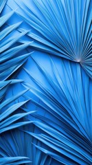 Fototapeta premium Artistic Blue Fan Palm Leaves Displayed Against A Solid Background
