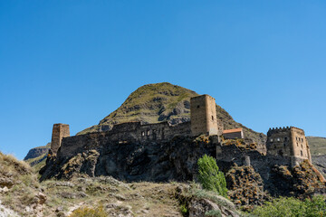 Historic Fortress on Rocky Hill with Stunning Backdrop
A striking image of a historic fortress atop a rugged hill, featuring stone towers and crenellated walls. Set against a mountainous backdrop and 