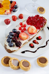 Delicious Breakfast with Toast Berries and Chocolate Cookies on a Light Background