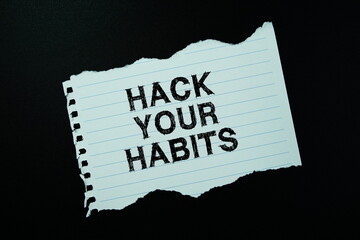 Hack Your Habits text written on paper flat lay on black background