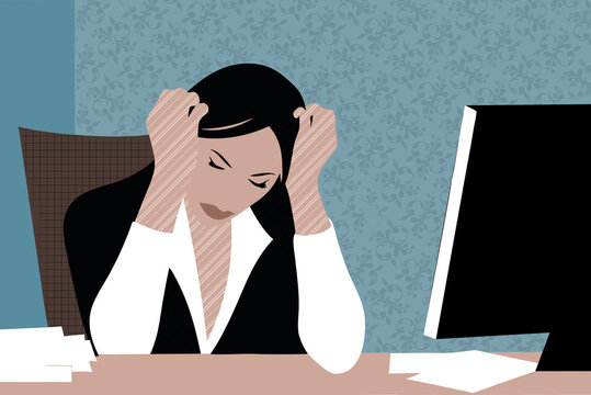 A woman sits at her desk in an office visibly frustrated