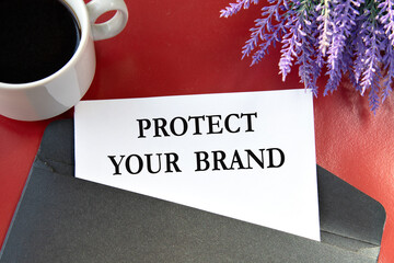 PROTECT YOUR BRAND - the words on white paper are on a black envelope on a red background.