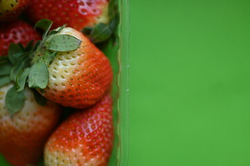 red juicy strawberries on a green background, summer photo background of strawberries as a background 