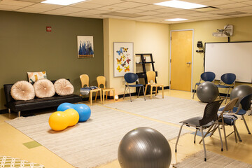 large basement studio with chairs, yoga balls, blankets, and a white board. room used for a lamaze class