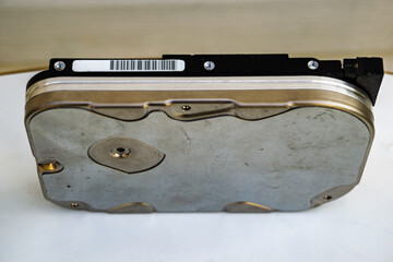 Used hard drive for computer on a white surface for disposal