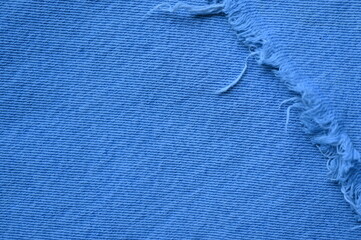 torn light grey denim surface, denim fringe , hole macro texture of blue denim, torn blue denim...