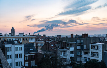 Obraz premium High angle view over backyards and rooftops in a residential area during an early morning sunrise in Jette, Brussels Capital Region