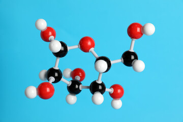 Molecule of glucose on light blue background. Chemical model
