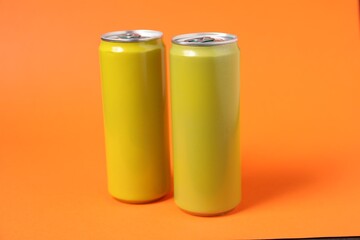 Two tin cans on orange background, closeup
