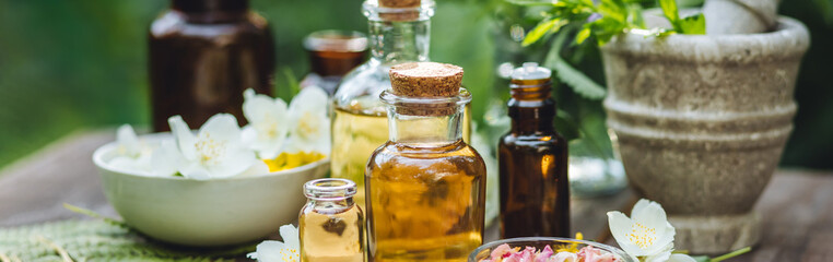 Herbal essential oil in old vintage apothecary glass bottles. Alternative medicine, skin care, aromatherapy and natural organic ingredients for medicine, pharmacy, fragrance cosmetic production banner