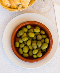 Clay bowl of green olives - tasty snack