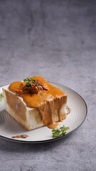 Bread bowl filled with creamy curry, topped with meat and garnished with herbs, served on a plate in a rich and comforting style.