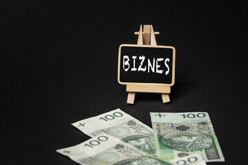 Black wooden writing board on a black background with the inscription 