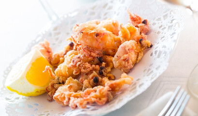 Crispy deep fried baby cuttlefish served with slice of lemon