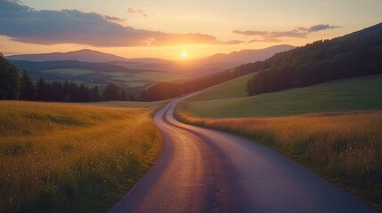 Winding road extending into the distance with the setting sun casting warm light across the landscape, framed by lush green hills and mountains, symbolizing the freedom of travel and exploration.