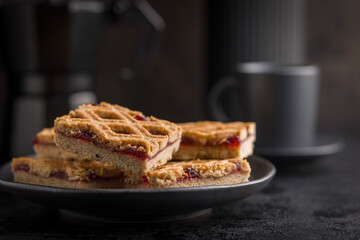 Sweet linzer cake on plate on black table.