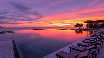 An expansive infinity pool reflects vibrant sunset colors over tranquil water
