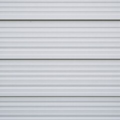 Metal wall with vertical corrugations in a silver-gray finish and textured lines