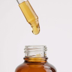Fototapeta premium Close-up image showcasing the detailed texture of Vitamin C serum droplets in a dropper bottle