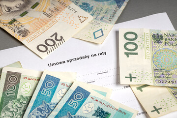 Contract of sale in installments. Empty document to fill out, scattered Polish money PLN. Translation: 